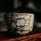 Kintsugi: a rough pottery cup with broken seams filled with gold