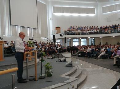 a preacher addresses a full room