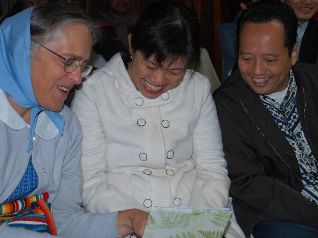 smiling asian couple looks at woman in headscarf