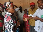  In this photo, James Kanyari, MCC staff, talks with project beneficiaries about the food distribution in Kibwezi village. 