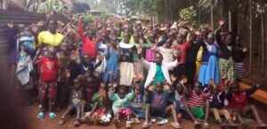 a group of African people wave at the camera
