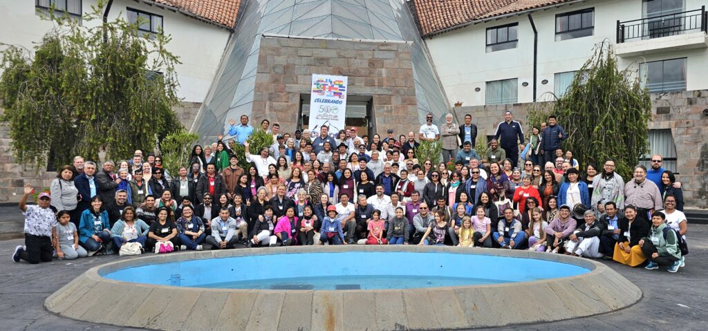 large group of people lined up for photo in the drop off loop of a hotel