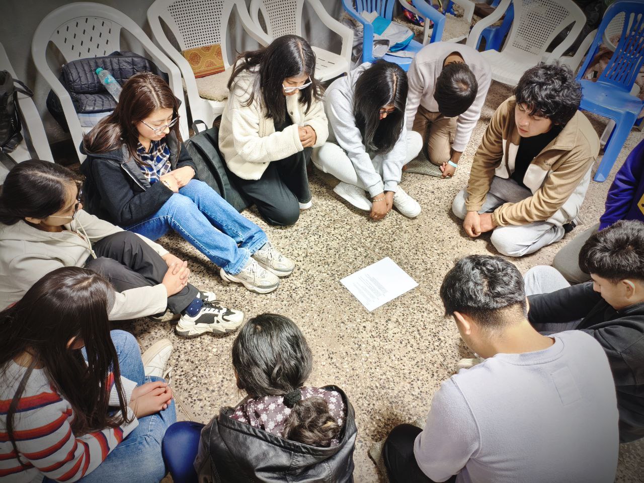 group of youth praying in circle in Peru